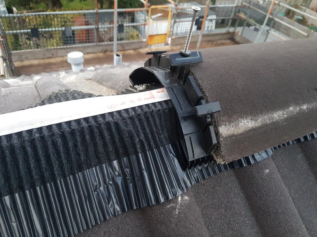 Close-up of dry ridge roll and mechanical ridge tile fixing